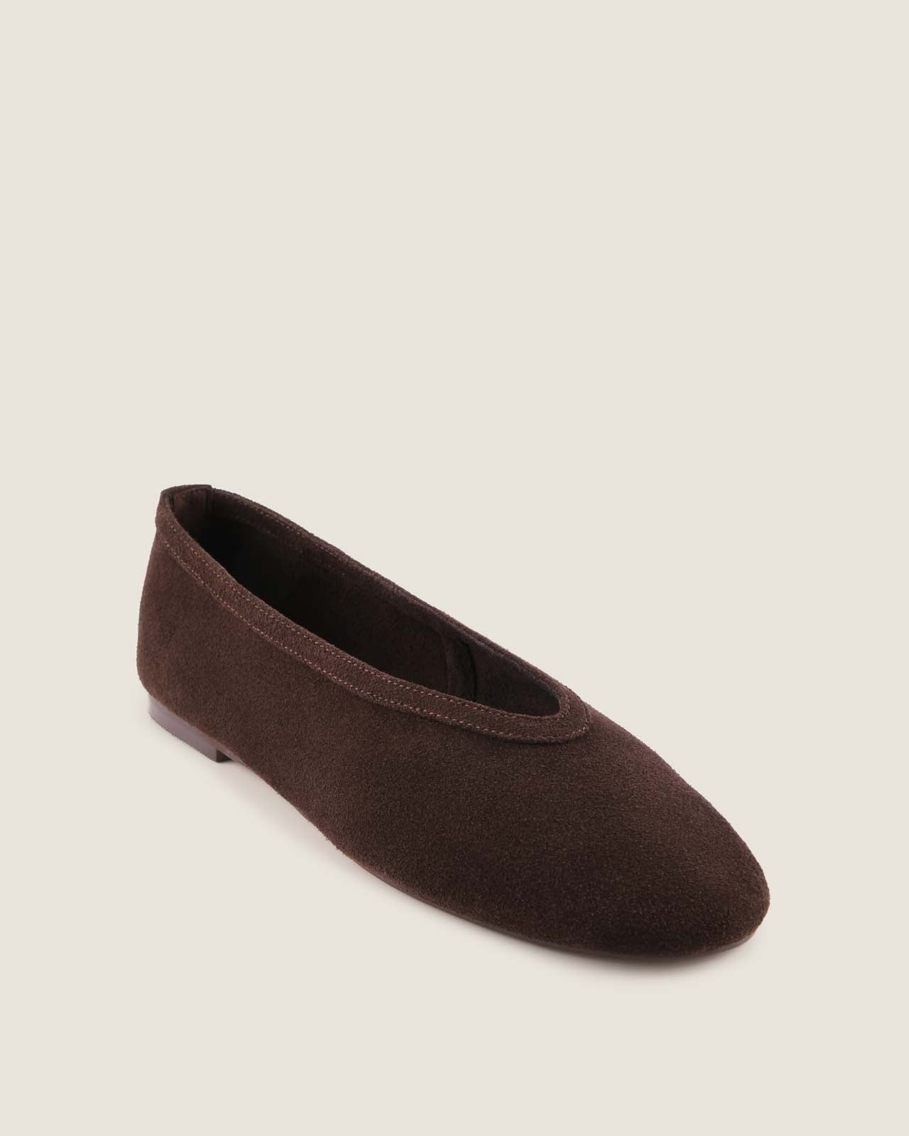 Brown flat shoe on a beige background