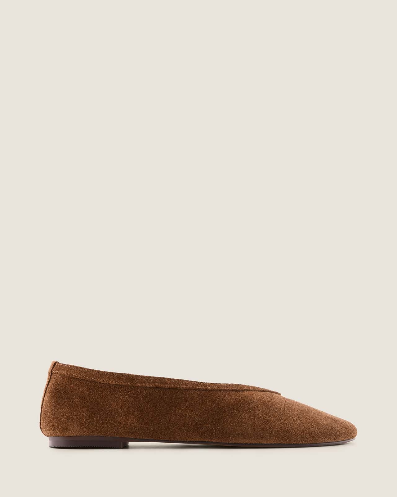 Brown suede flat shoe on a light beige background