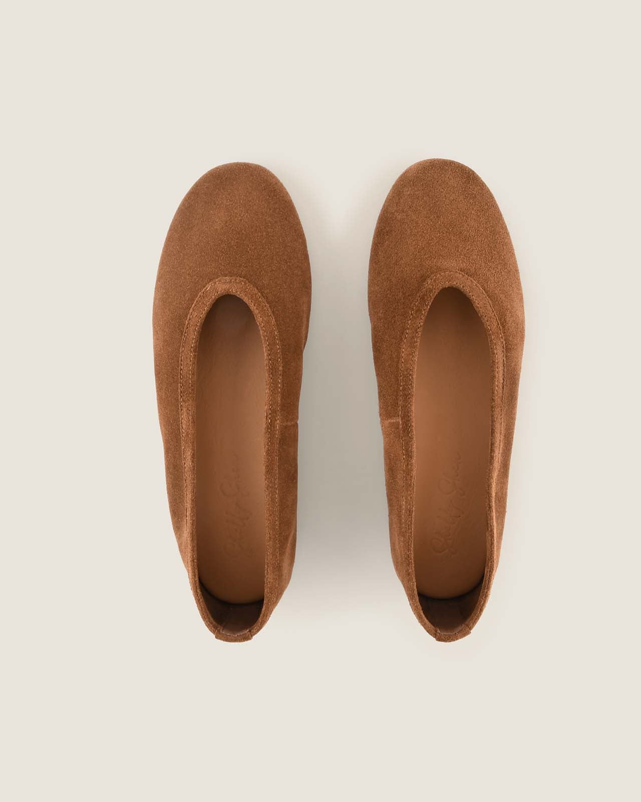 Pair of brown loafers on a light beige background