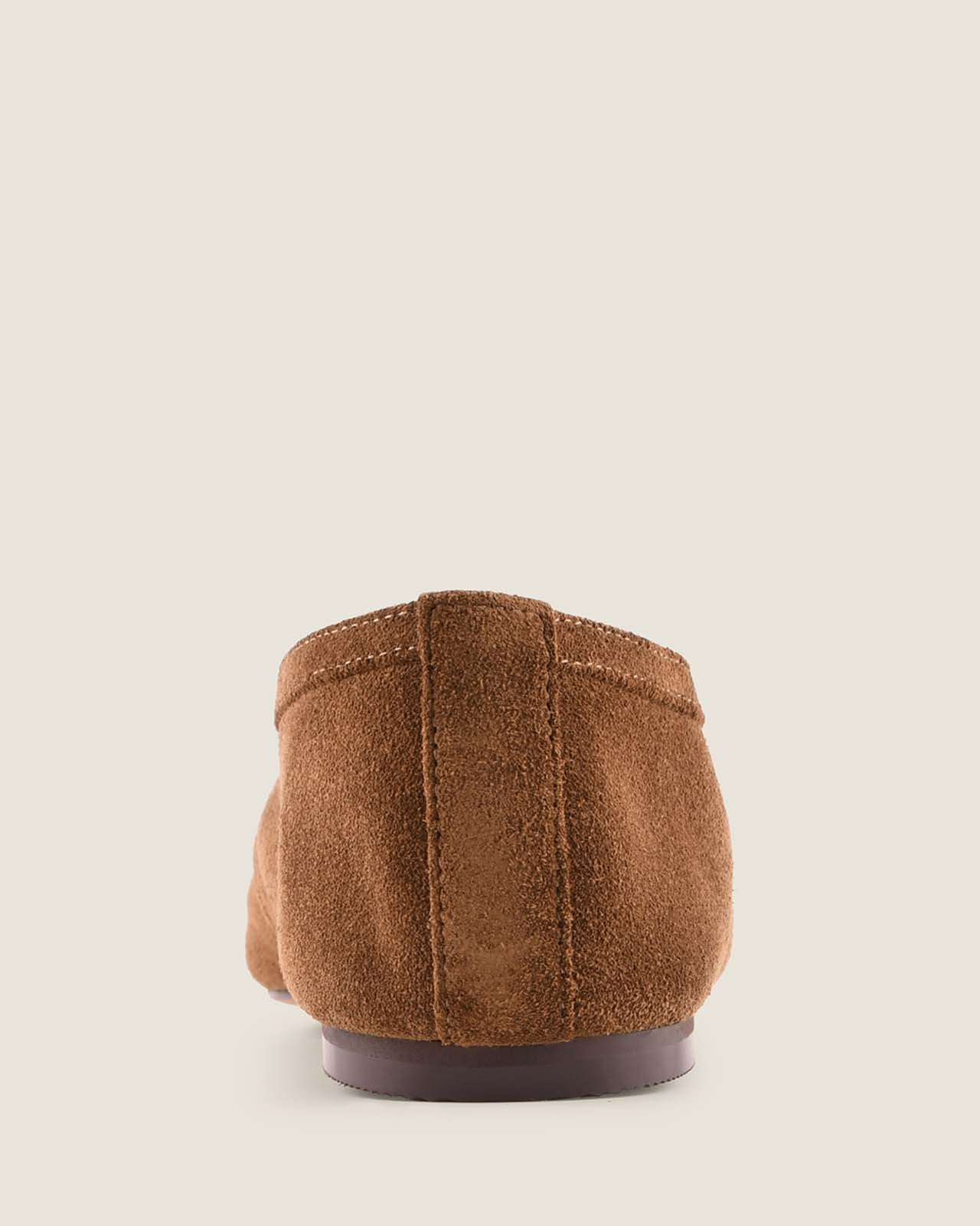 Brown suede shoe sole on a light beige background