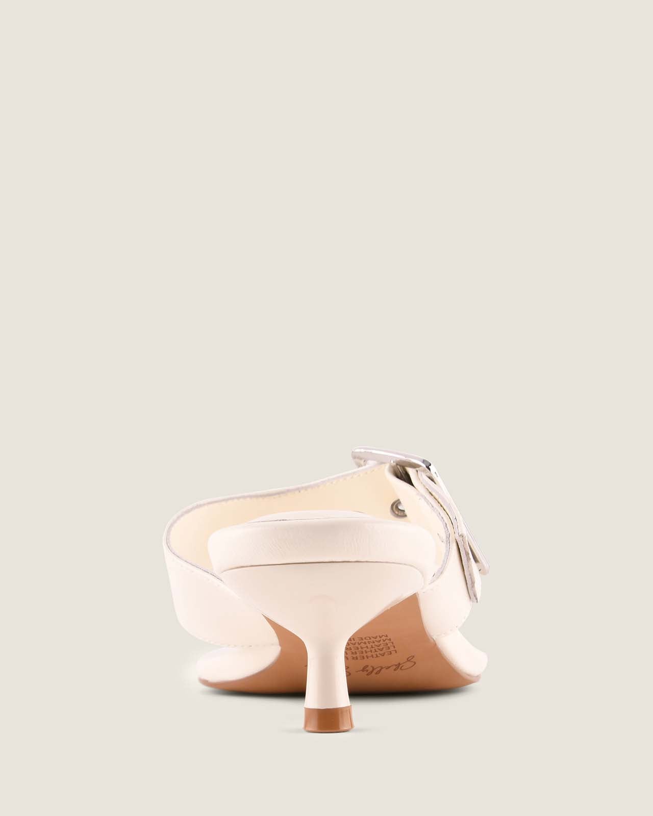 White high-heeled shoe with a bow on a light gray background