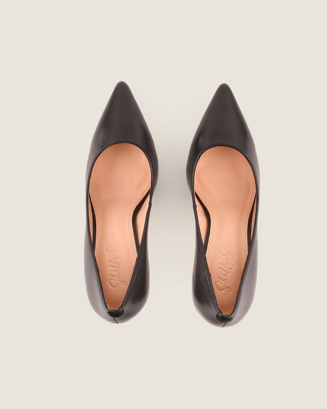 Pair of black high-heeled shoes on a light gray background