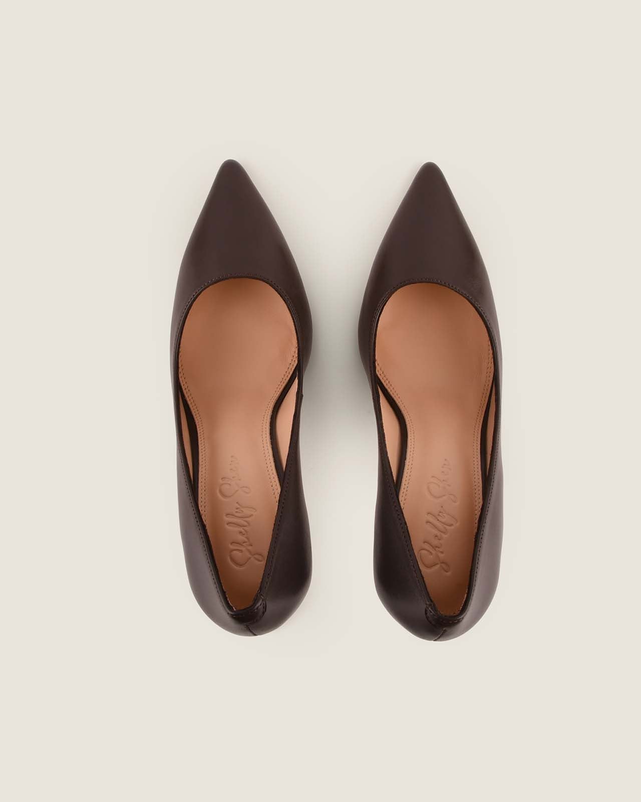 Pair of brown pointed-toe shoes on a light gray background