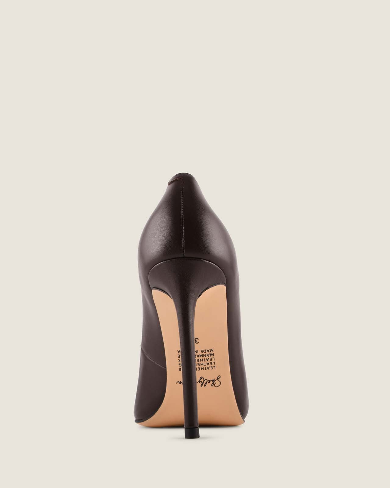 Black high-heeled shoe on a light beige background