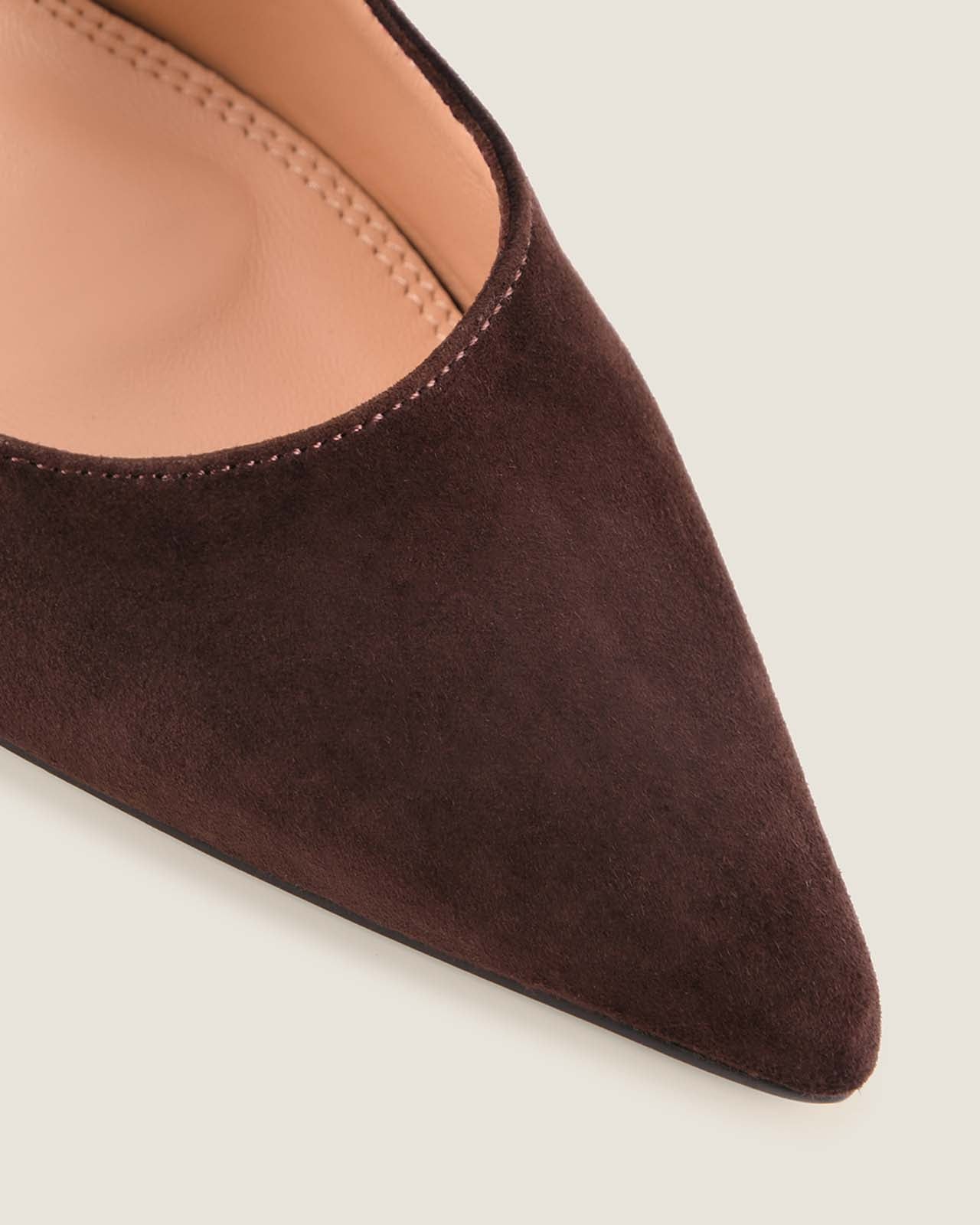 Brown suede shoe with a pointed toe on a light background
