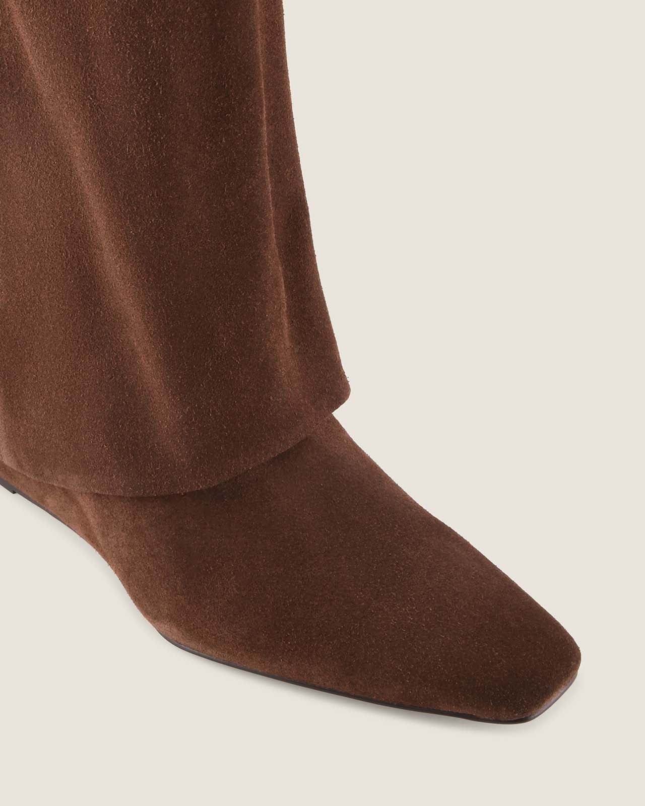 Brown ankle boot on a light beige background