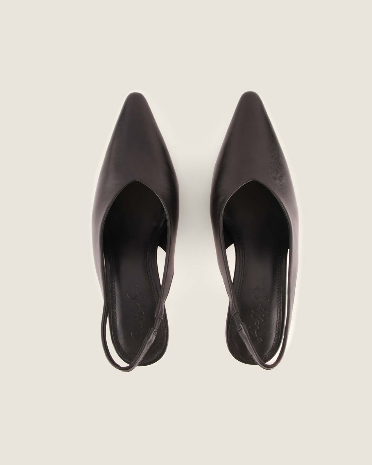 Pair of black high-heeled shoes on a light gray background