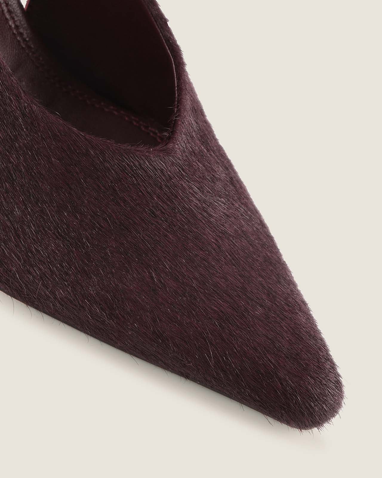 Close-up of burgundy pony hair pointed shoe on a light background