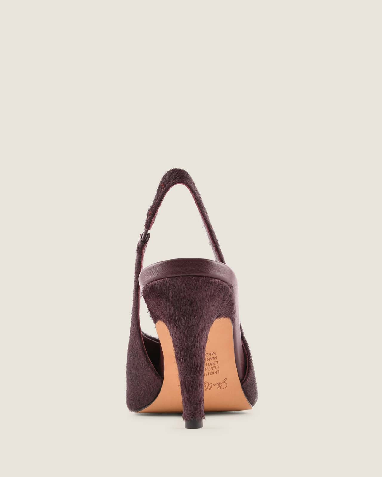 Purple high-heeled shoe with a tan sole on a light beige background